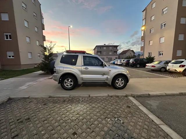 Bočni pogled na srebrni terenac između zgrada