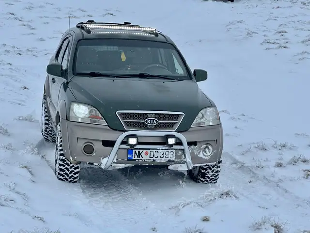 Prednji pogled na zeleni terenac sa zimskim gumama