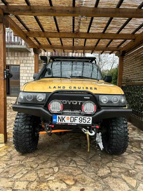 Prednji pogled na žuti terenac pod drvenom nadstrešnicom