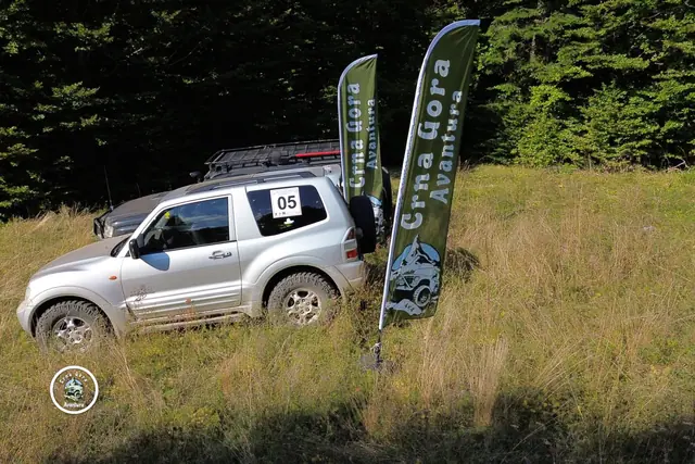 Srebrni terenac i zastava 4×4 Avantura na livadi