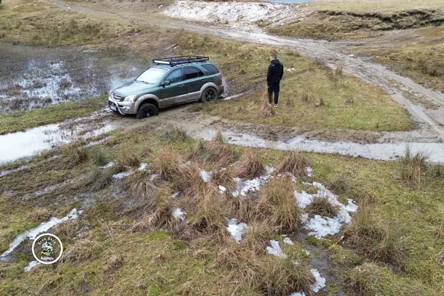 Srebrni terenac na krivini makadamskog puta