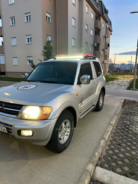 Srebrni terenac parkiran između stambenih zgrada