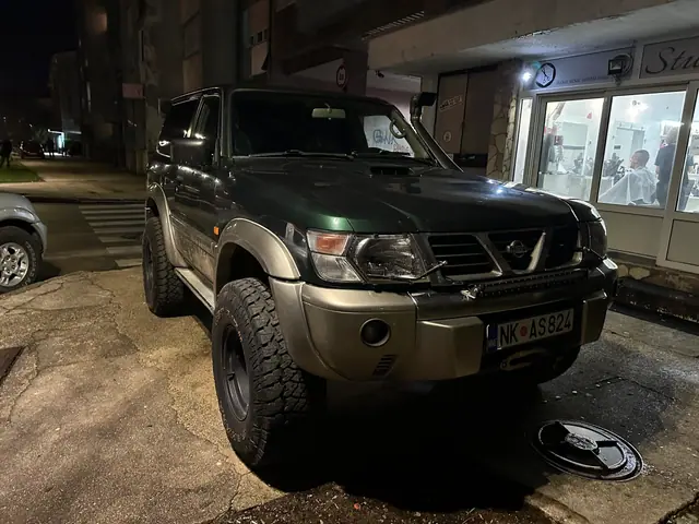 Tamni terenac sa terenskim gumama ispred osvijetljenih lokala