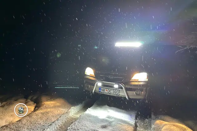 Terenac sa upaljenom krovnom rasvjetom na snijegu