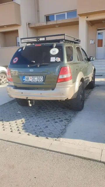 Zeleni terenac sa oznakama udruženja parkiran ispred objekta